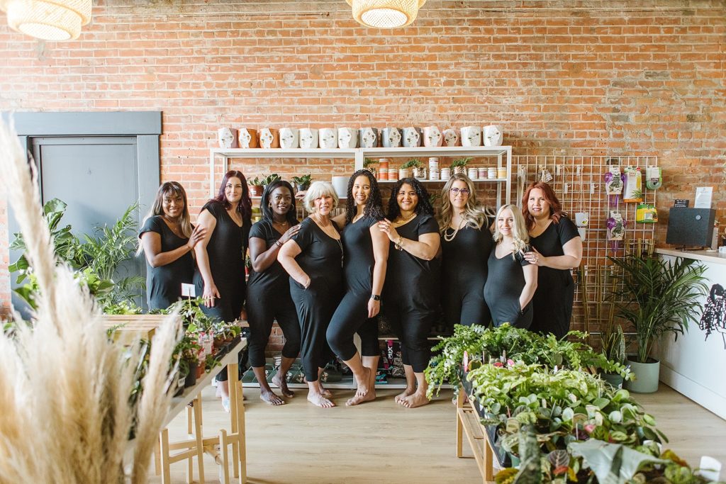 Group of models standing inside The Sill & Soil in Lethbridge, AB wearing 4Fold Threads rompers