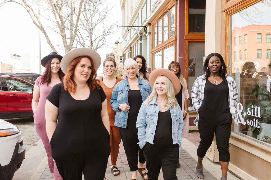 Group of models walking down street outside The Sill & Soil in Lethbridge, AB wearing 4Fold Threads rompers