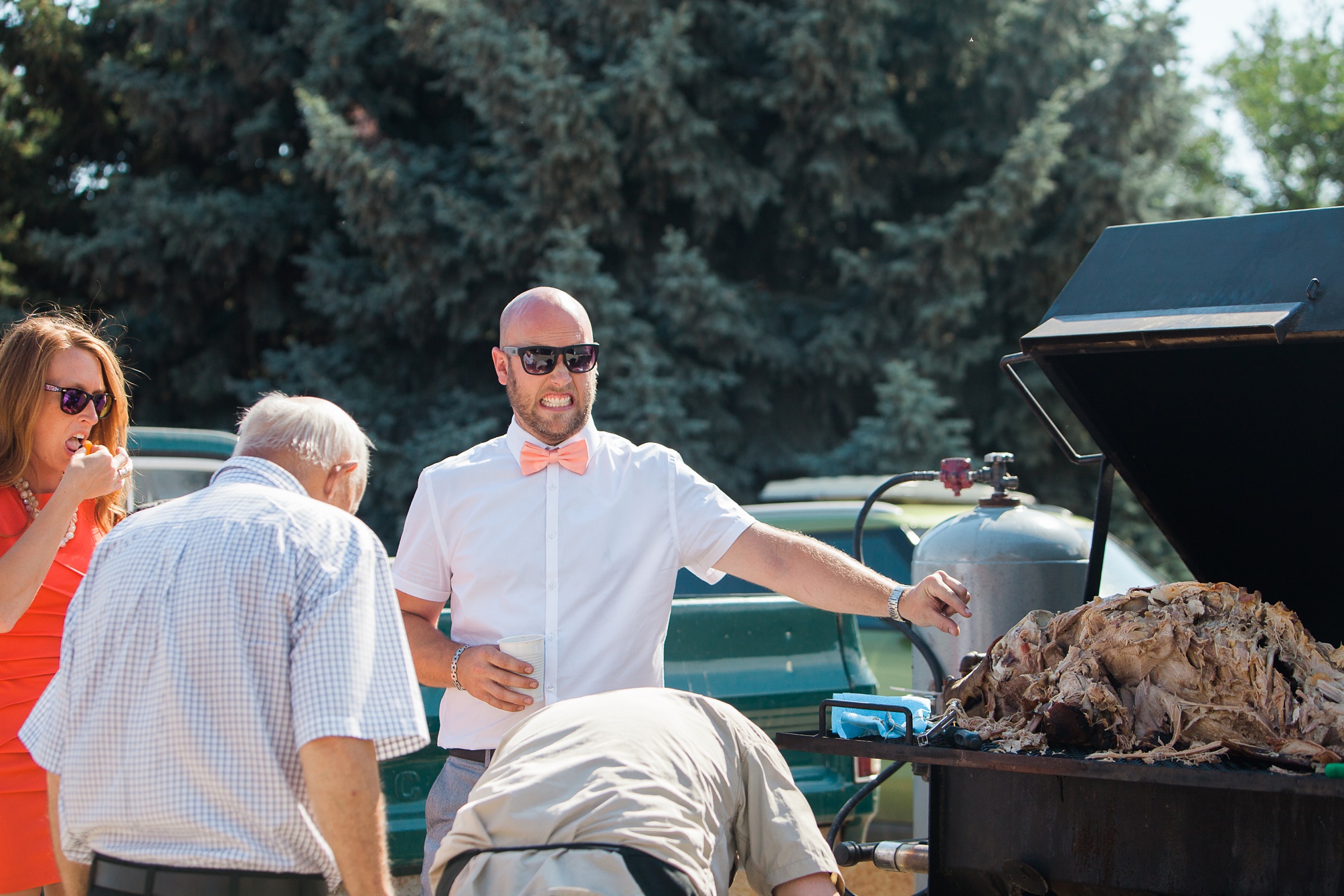 Pig roast at this casual pink and white backyard wedding 