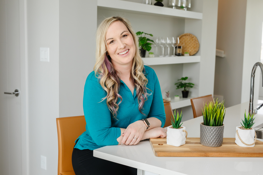 Lethbridge small business owner Courtney Marchesin with Pampered Chef, leaning on the counter.