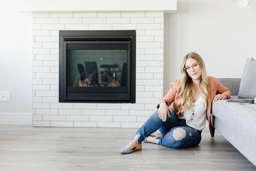 Tamara Rzan is a Crowsnest Pass realtor, and she is pictured here sitting on the floor in a home. Pose example by Kinsey Holt Photography