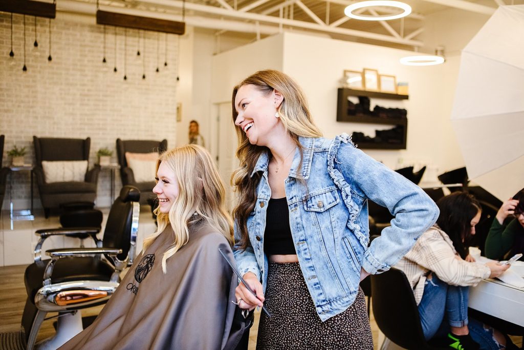 Stylist and client laughing together at the Salon in Brooks, captured by Lethbridge brand photographer Kinsey Holt