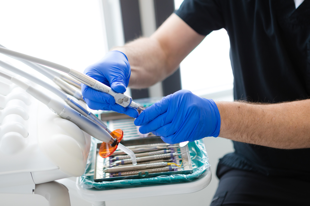 Dental tools held by rubber gloved hands as an example of Lethbridge dentist photography