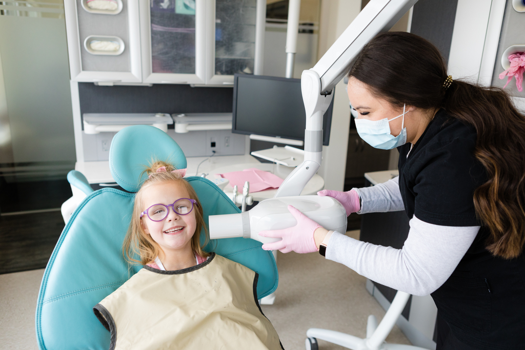 Smiling young girl in dentist chair at Absolute Dental for Lethbridge dentist photography