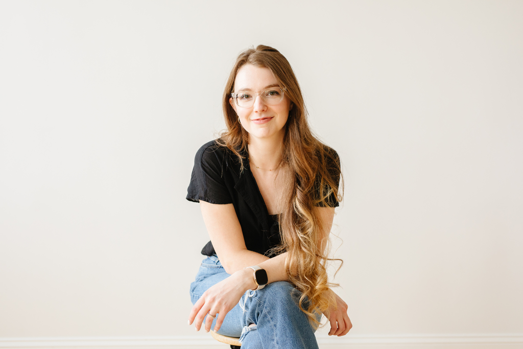 A woman leaning forward, smiling at the camera in blog post about the benefits of brand photography