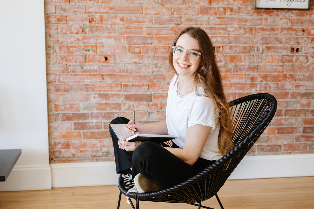 Keyana from Key Creative Co, sitting in a chair journaling. Shot by Lethbridge designer photographer 
