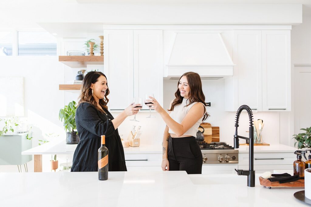 Cheers! Two women clinking wine glasses. Brand photography by Kinsey Holt