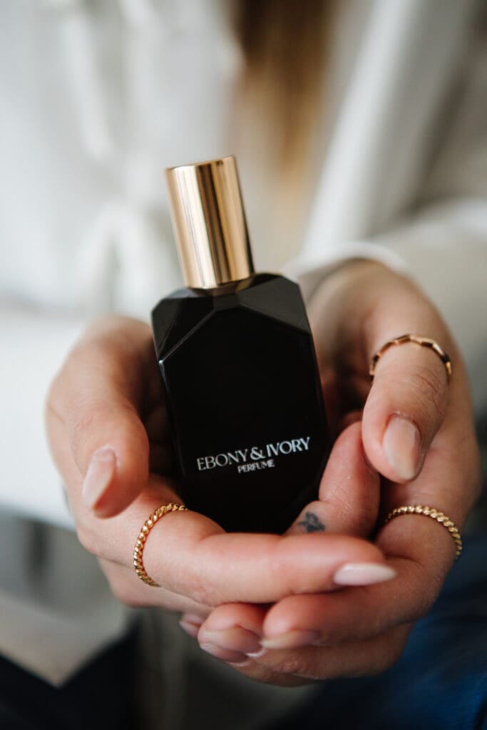Hands holding high-end perfume, by Ebony and Ivory Co and shot by Lethbridge luxury product photographer